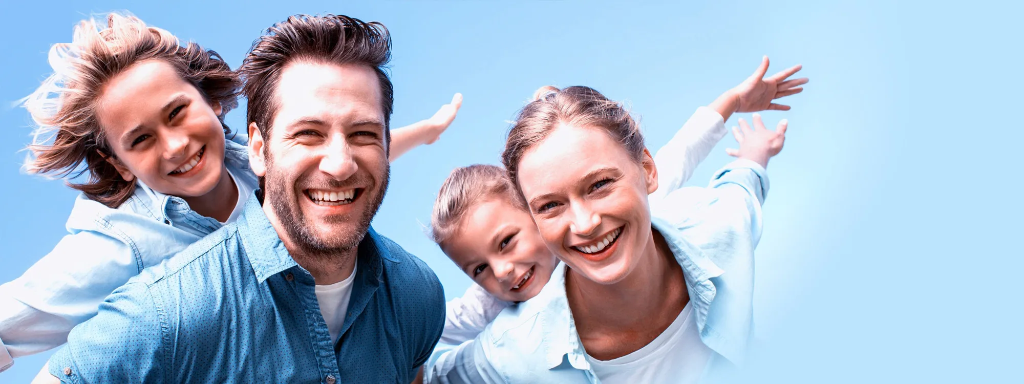 Smiling family against blue sky